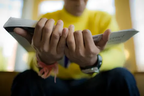 Someone reading a book with their hands in the forefront